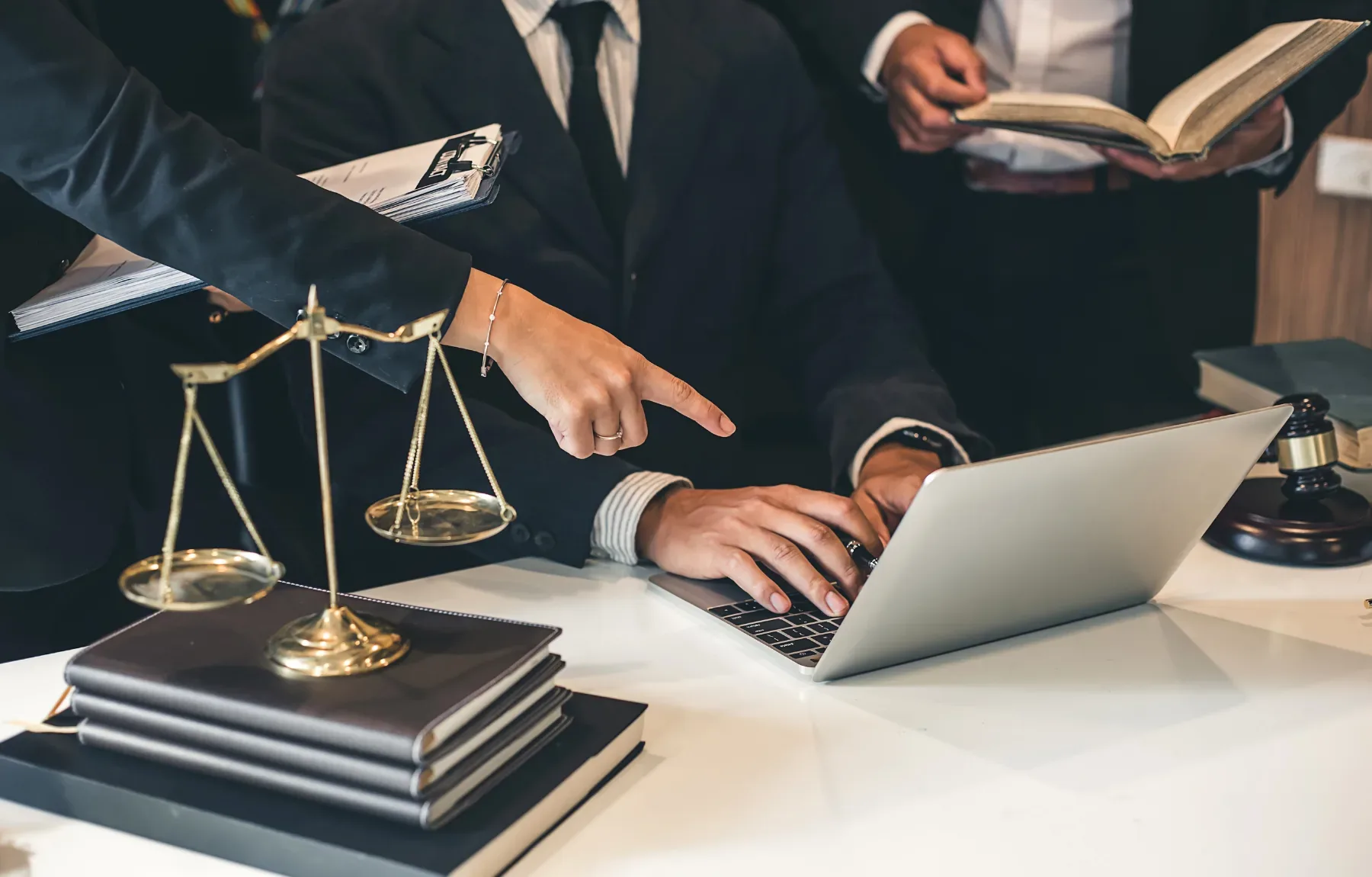Professional lawyers collaborate on case research using technology and legal resources in a modern law office setting with sc